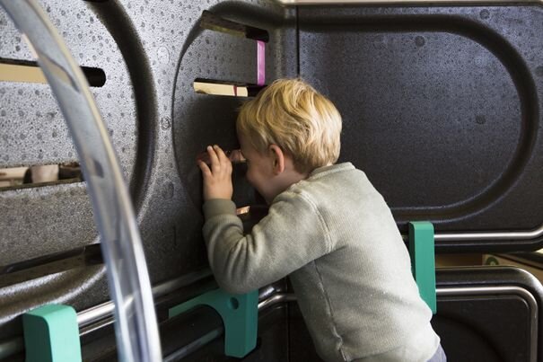 Kind die zich verstopt heeft in een hop up speeltuig.